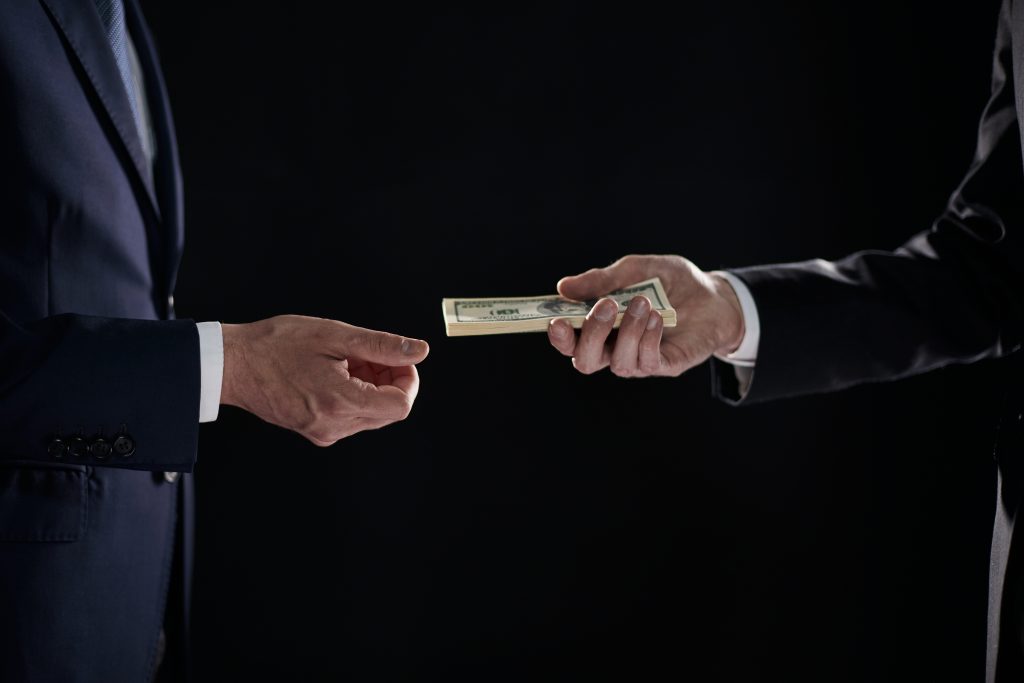Money transfer between colleagues on a black background