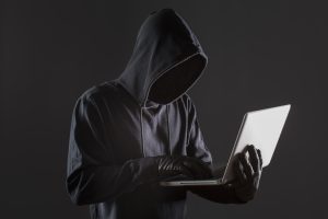 vista-lateral-del-pirata-informatico-masculino-con-guantes-y-portatil