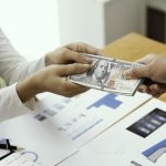 businessman-giving-or-paying-money-us-dollar-bills-free-photo