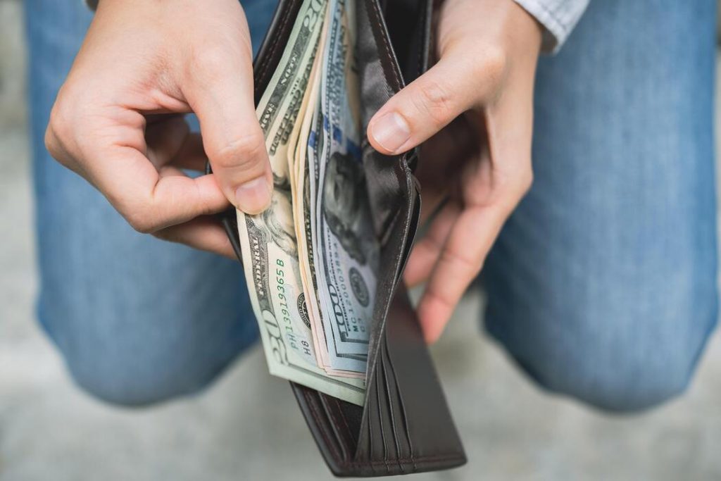 businessman-s-hands-opening-his-wallet-taking-out-money-finance-and-tax-concept-photo