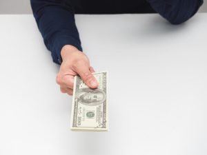 man-hand-giving-money-dollar-on-the-table-earn-salary-concept-free-photo